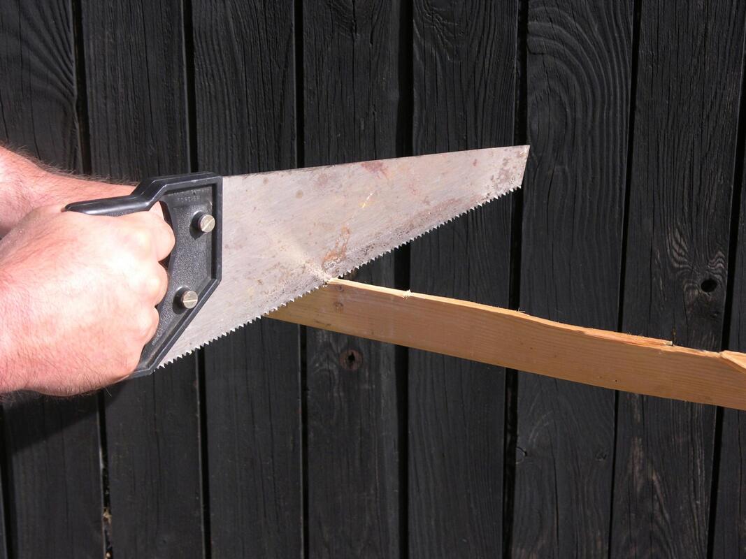 worker using the handsaw